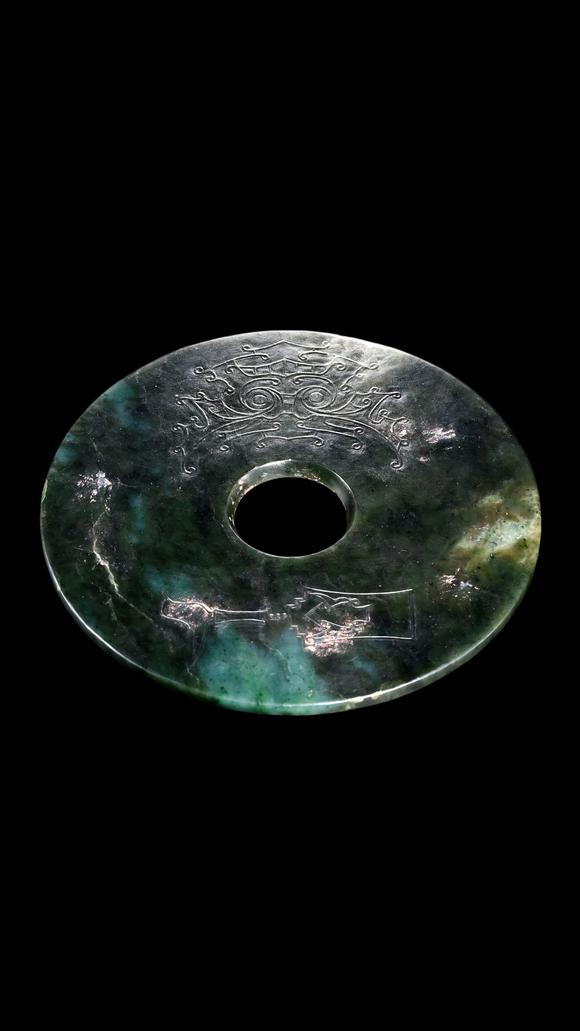 Castle AuctionA Dark Green Jade Bi Disc with Incised Decoration, Neolithic, Circa 3300–2300 C BC Pr.