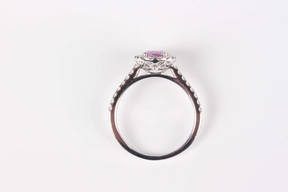 TooveysA platinum, pink sapphire and diamond oval cluster ring, claw set with the oval mixed cut pink sapphire within a surround of circular cut diamonds, be
