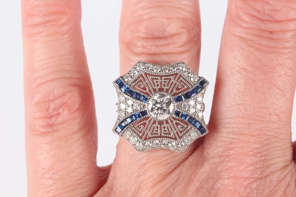 TooveysA platinum, sapphire and diamond ring, collet set with the principal circular cut diamond at the centre, otherwise in a pierced millegrain design, det