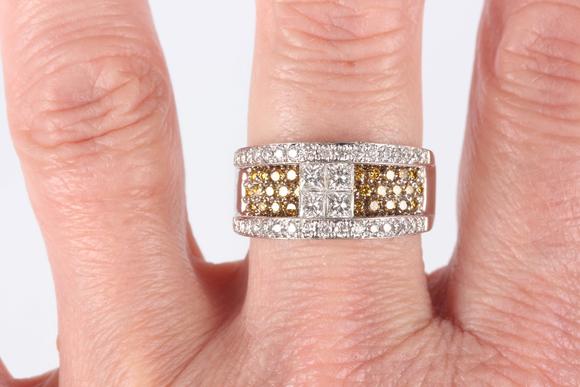 TooveysA white gold, diamond and treated yellow diamond ring in a raised design, the centre set with four principal princess cut diamonds between circular cu
