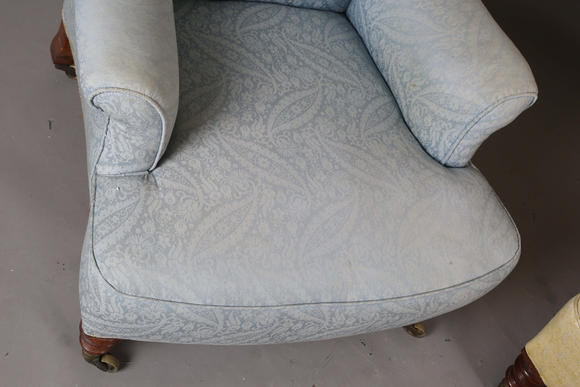 TooveysA near pair of late Victorian Howard & Sons armchairs, each buttoned back above scroll arms, on turned walnut legs with gilt brass caps and castors, e