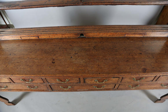 TooveysA good George III North Country oak dresser, the plate rack with pierced side panels above a lappet carved frieze and an arrangement of nine drawers,
