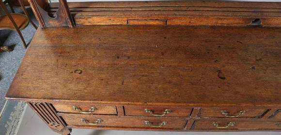 TooveysA good George III North Country oak dresser, the plate rack with pierced side panels above a lappet carved frieze and an arrangement of nine drawers,
