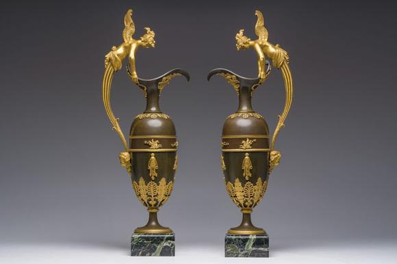 Coronari Auctions BVAn impressive pair of French Empire gilt and patinated bronze ewers on marble bases, attributed to Claude Galle, ca. 1800-1810