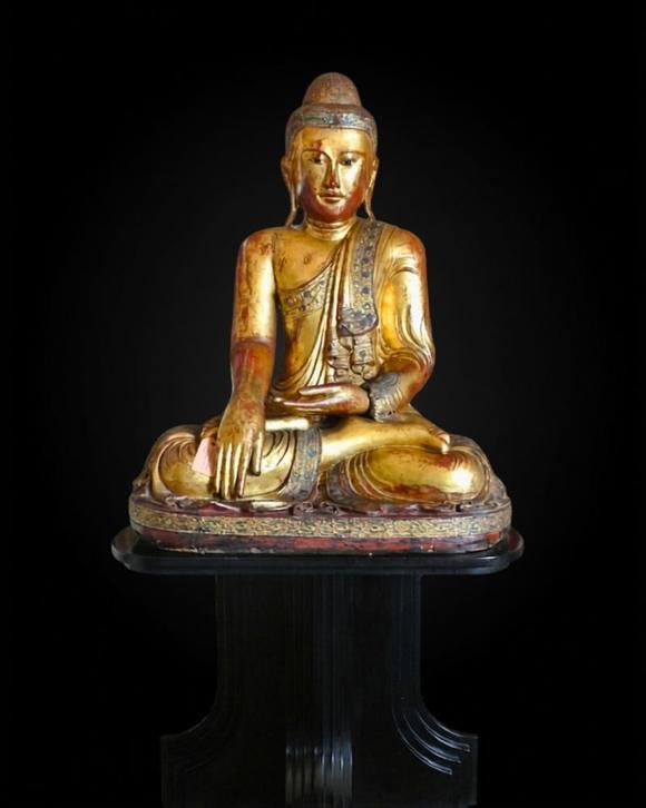 Bertolami Fine ArtBuddha figure in the lotus position. Lacquered and gilded wood with stucco and glass paste applications, set on a wooden and black lacquer base. Burma, Mandalay, 19th century.