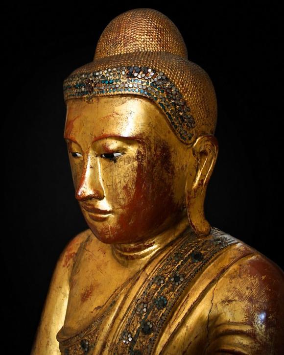 Bertolami Fine ArtBuddha figure in the lotus position. Lacquered and gilded wood with stucco and glass paste applications, set on a wooden and black lacquer base. Burma, Mandalay, 19th century.