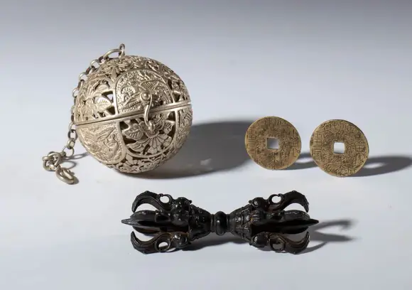 Bertolami Fine ArtLot comprising a silver-plated metal gyroscope sphere, two hand-engraved Kangxi Tongbao coins, and a copper alloy vajra. China, 20th century.