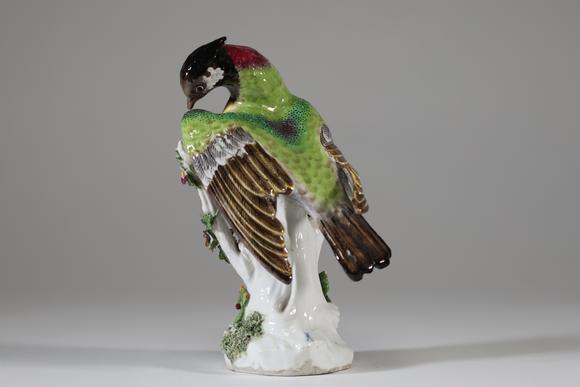 Goldfield Auction sarlsSujet en porcelaine allemande représentant un oiseau perché sur un tronc fleuri, le plumage finement polychromé et rehaussé d’or, reposant sur une ba