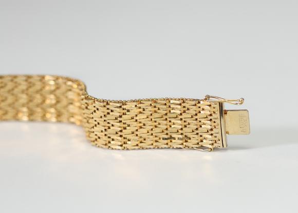 Goldfield Auction sarlsBracelet manchette en or jaune à décor ajouré et articulé, composé de multiples rangs de maillons géométriques finement travaillés, fermoir intégré. T