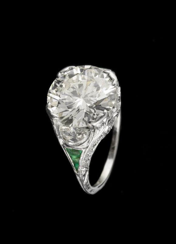Piguet - H?tel des VentesBague Art Déco platine centrant un diamant taille brillant entouré de diamants taille demi-lune et 8/8 ainsi que d'émeraudes calibréesArt Déco platinum ring set with one center diamond, half-moon and 8/8 cut diamonds and calibrated-cut emeralds