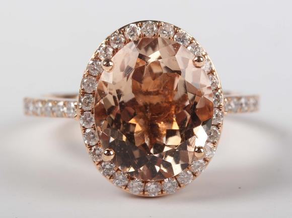 TooveysAn 18ct gold, morganite and diamond oval cluster ring, claw set with