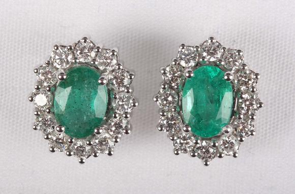 TooveysA pair of white gold, emerald and diamond oval cluster earstuds, eac