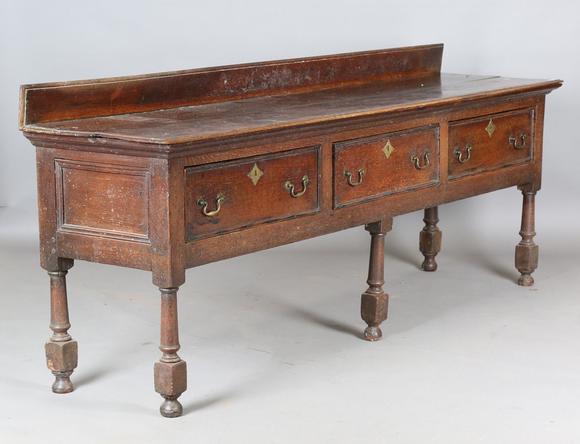 TooveysAn 18th century provincial oak dresser base, fitted with three drawe
