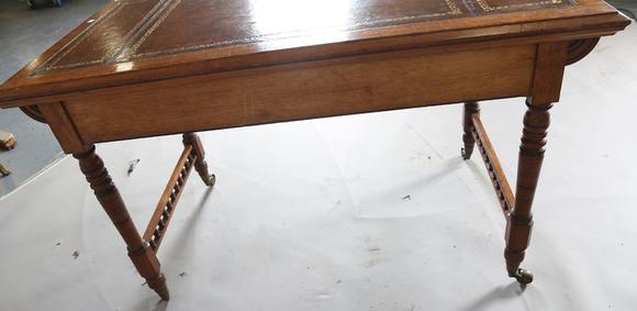 TooveysA late Victorian oak writing table, the top inset with gilt-tooled b