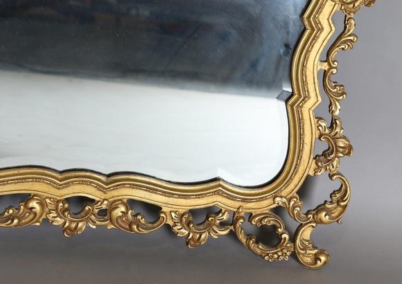 TooveysA late 20th century gilt composite wall mirror of shaped form, the f