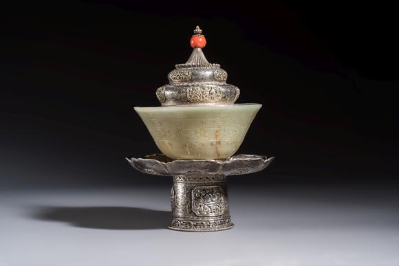 Rob Michiels AuctionsA Tibetan ritual jade bowl with a red coral-mounted silver cover and a stand, 19th C.
