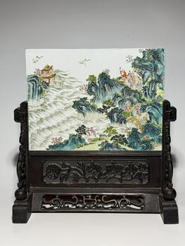 Plaque rectangulaire famille rose encadrée bois sculpté à paysage de montagne et mer, personnages et grues volantes, 18 siècle