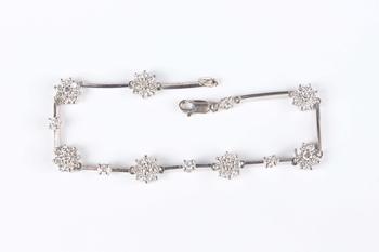 An 18ct white gold and diamond bracelet, designed as seven diamond set clusters alternating with four single stone diamond divisions, on a sprung hook