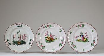 Lot de trois assiettes en fa?ence à bord contourné, à décor polychrome de personnages chinois dans des paysages stylisés, dans le go?t des décors chin