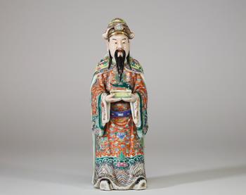 Chine, XIXe siècle, important personnage en porcelaine de la famille rose représentant un dignitaire tenant un plateau d’offrande, vêtu d’une riche