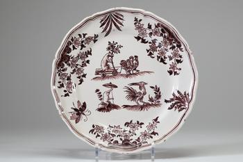 Moustiers, assiette en fa?ence à bord contourné, décor en cama?eu manganèse de grotesques et scènes animalières fantaisistes dans des réserves fleurie