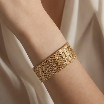 Bracelet manchette en or jaune à décor ajouré et articulé, composé de multiples rangs de maillons géométriques finement travaillés, fermoir intégré. T