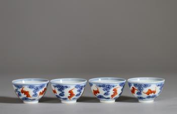 Chine, ensemble de quatre petits bols en porcelaine à décor en bleu sous couverte et rouge de fer de chauves-souris évoluant parmi des nuages stylisés