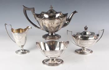 A George V silver teapot of shaped oval form, engraved with floral a